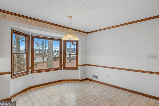 spare room with ornamental molding and a textured ceiling