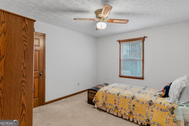 carpeted bedroom with ceiling fan and a textured ceiling