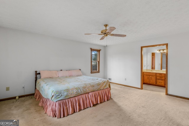 carpeted bedroom featuring ensuite bathroom, ceiling fan, and a textured ceiling