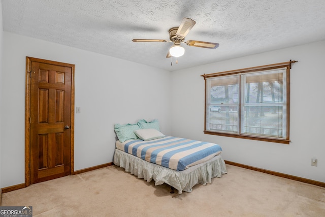 carpeted bedroom with ceiling fan and a textured ceiling