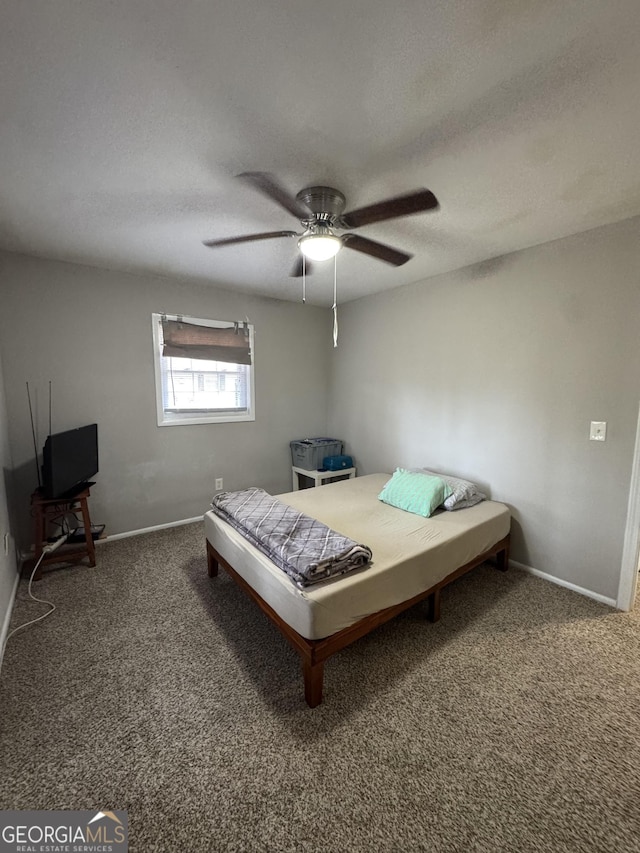 bedroom with ceiling fan, a textured ceiling, and dark carpet