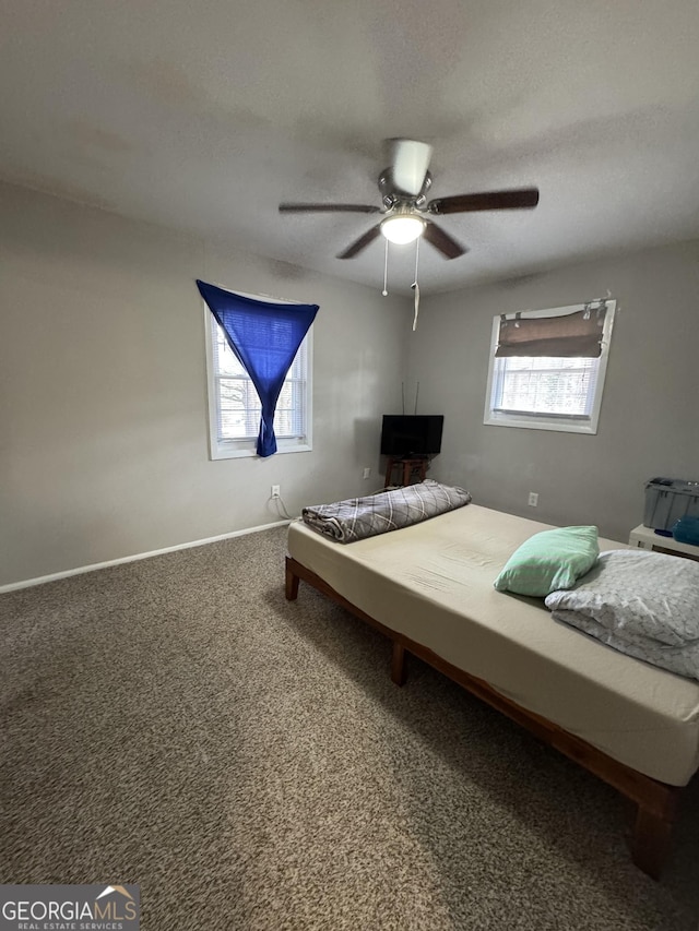 carpeted bedroom with ceiling fan and a textured ceiling