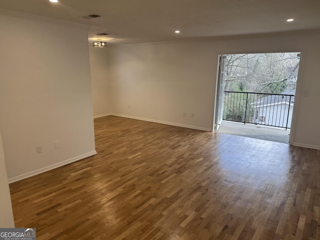 spare room with dark wood-type flooring and crown molding