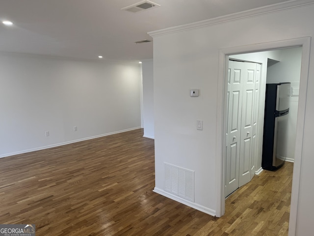 unfurnished room featuring crown molding and dark wood-type flooring