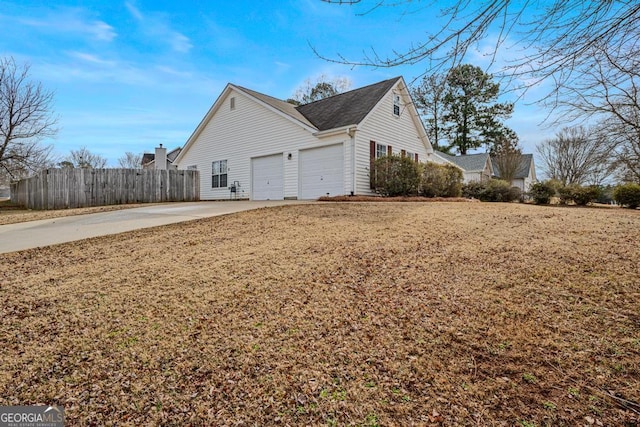 view of side of property featuring a garage and a lawn