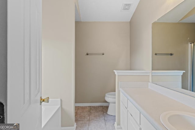 bathroom with vanity, a tub, tile patterned floors, and toilet