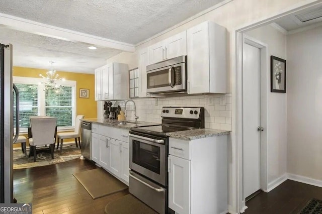 kitchen with dark hardwood / wood-style floors, sink, white cabinets, backsplash, and stainless steel appliances