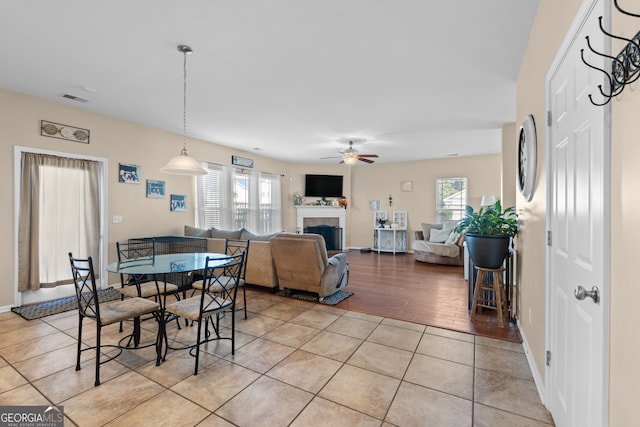 dining space with light tile patterned floors, a healthy amount of sunlight, and ceiling fan