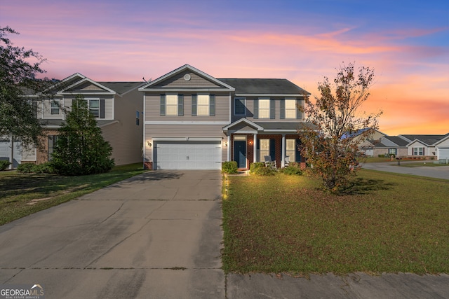 front of property with a garage and a yard