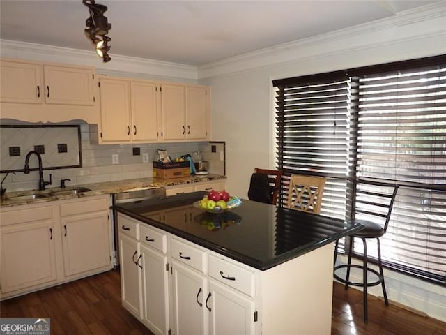 kitchen with white cabinetry, a healthy amount of sunlight, sink, and a kitchen island