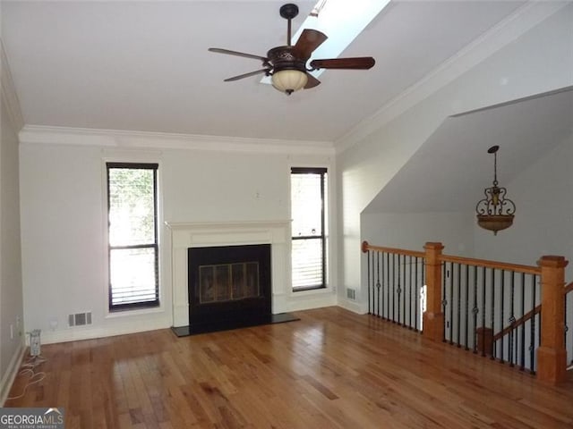 unfurnished living room featuring ceiling fan, ornamental molding, and wood-type flooring