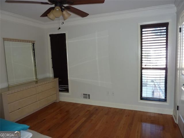 unfurnished bedroom featuring hardwood / wood-style flooring, ornamental molding, and ceiling fan