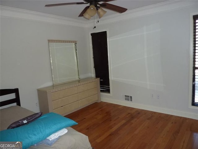 bedroom featuring crown molding, multiple windows, and hardwood / wood-style flooring