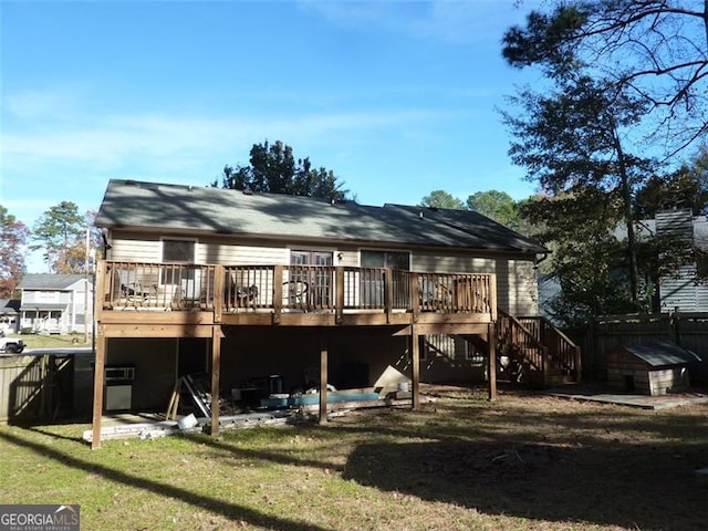 rear view of house with a deck and a lawn