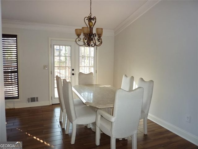 dining space with crown molding, dark hardwood / wood-style floors, and a chandelier