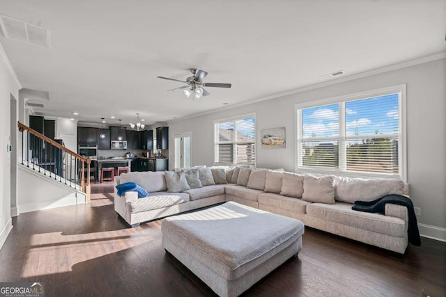 living room featuring dark hardwood / wood-style flooring, a wealth of natural light, and ornamental molding