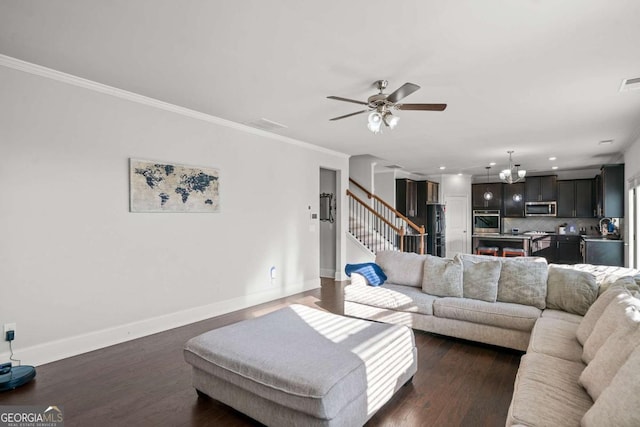 living room with sink, ornamental molding, dark hardwood / wood-style floors, and ceiling fan with notable chandelier