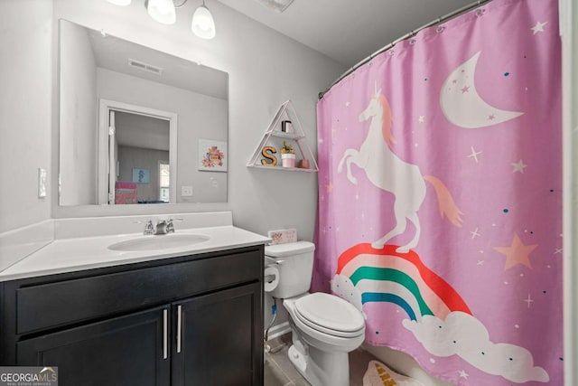 bathroom featuring vanity, toilet, and walk in shower