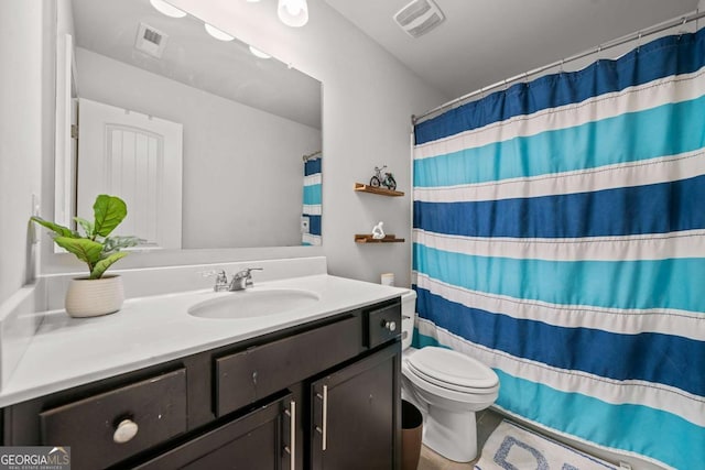 bathroom with vanity, a shower with shower curtain, and toilet