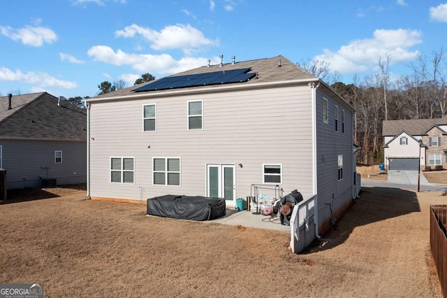 rear view of house with solar panels, a yard, central air condition unit, and a patio area