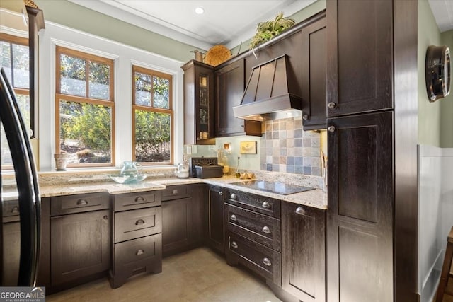 kitchen with premium range hood, dark brown cabinets, light stone counters, and black appliances