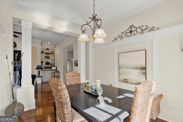 dining room with crown molding, dark wood-type flooring, a notable chandelier, and built in features