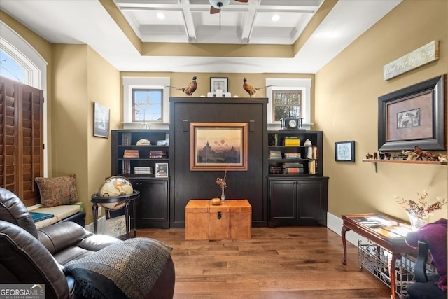 living area featuring coffered ceiling, hardwood / wood-style floors, and beamed ceiling