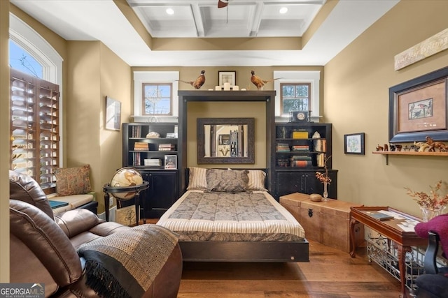 living area with coffered ceiling, hardwood / wood-style floors, and beam ceiling