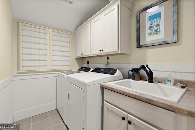 laundry area with cabinets, washer and dryer, sink, and light tile patterned floors