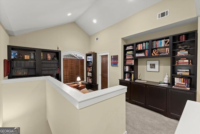 carpeted office space with vaulted ceiling