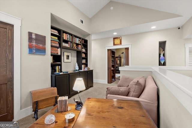 carpeted home office with high vaulted ceiling