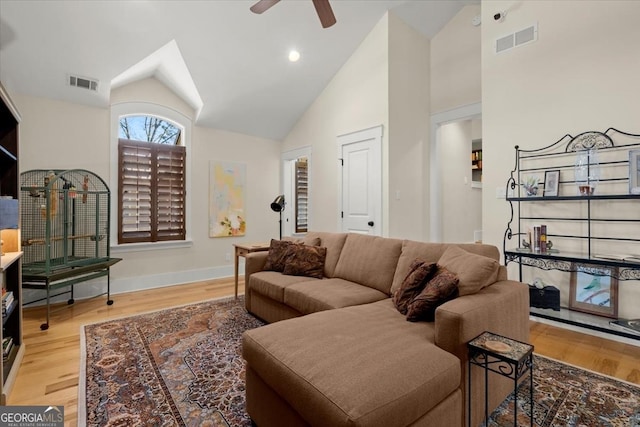 living room with wood-type flooring, high vaulted ceiling, and ceiling fan