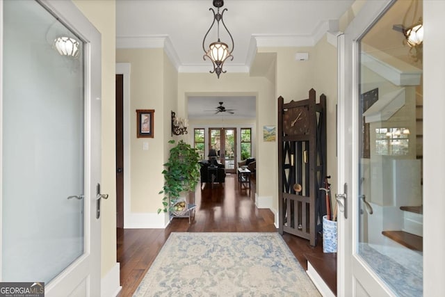 entryway with ornamental molding, dark hardwood / wood-style floors, an inviting chandelier, and french doors