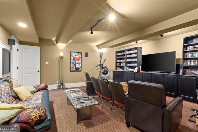 carpeted home theater featuring beam ceiling and rail lighting