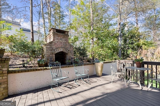 wooden terrace featuring an outdoor brick fireplace