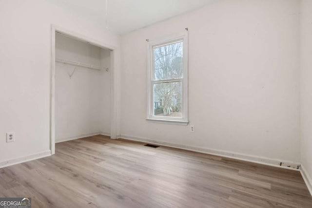 unfurnished bedroom with light hardwood / wood-style floors and a closet