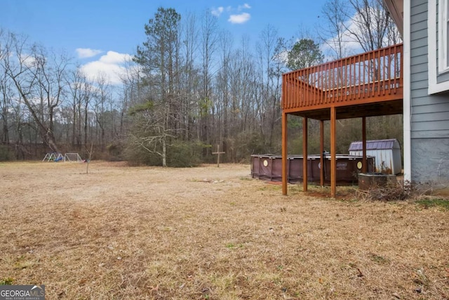 view of yard featuring a wooden deck and a jacuzzi