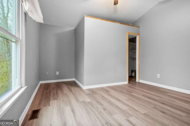 unfurnished room featuring ceiling fan, a healthy amount of sunlight, and light wood-type flooring