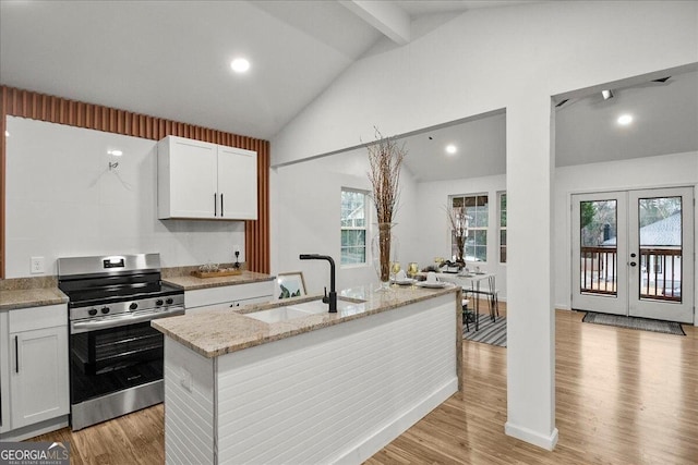 kitchen with stainless steel electric range, white cabinetry, sink, a kitchen island with sink, and french doors