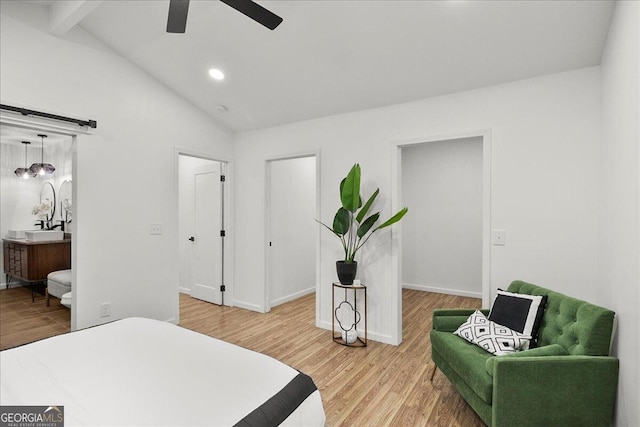 bedroom featuring wood-type flooring, vaulted ceiling with beams, connected bathroom, and ceiling fan