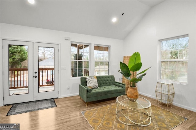 interior space with vaulted ceiling, french doors, and light wood-type flooring