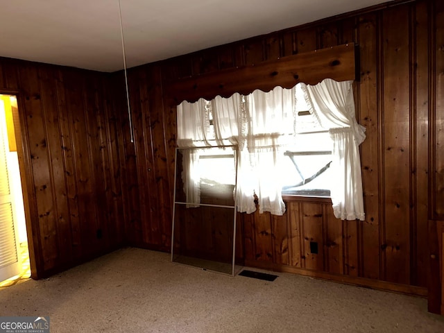 spare room featuring wooden walls