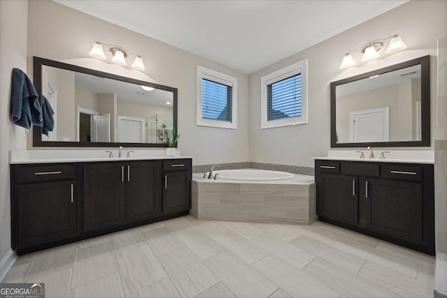 bathroom with vanity and a relaxing tiled tub