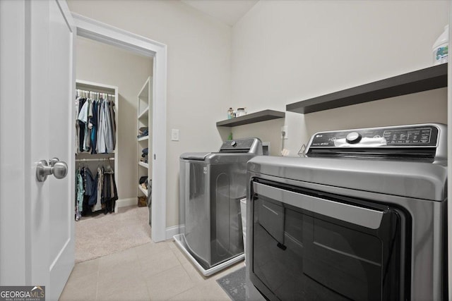 clothes washing area featuring light colored carpet and washer and dryer