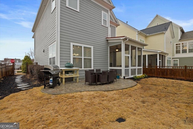 rear view of property with a sunroom, a lawn, and a patio area