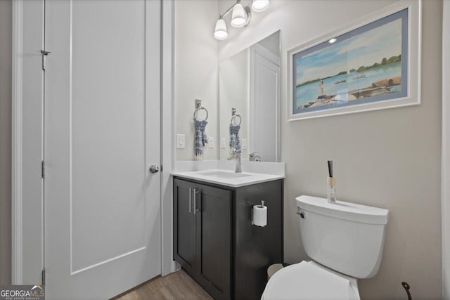 bathroom with vanity, toilet, and wood-type flooring