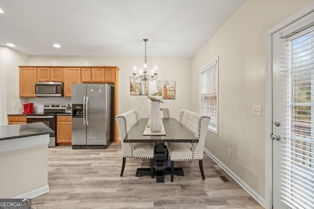 dining room with an inviting chandelier and light hardwood / wood-style flooring