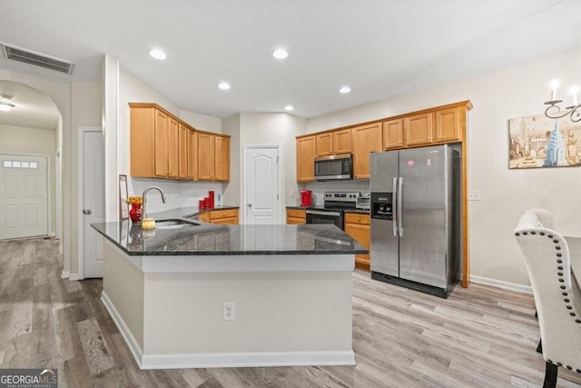 kitchen featuring appliances with stainless steel finishes, sink, light wood-type flooring, and kitchen peninsula