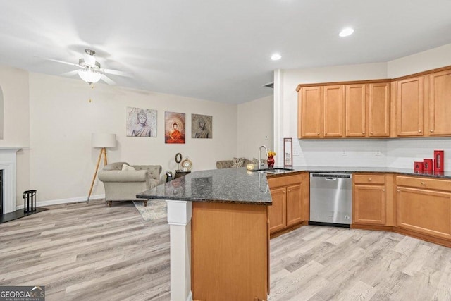 kitchen with sink, dark stone counters, stainless steel dishwasher, kitchen peninsula, and light hardwood / wood-style flooring