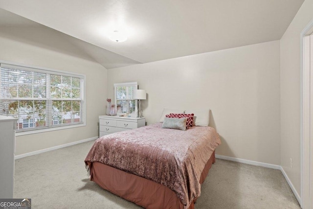 bedroom with vaulted ceiling and light carpet